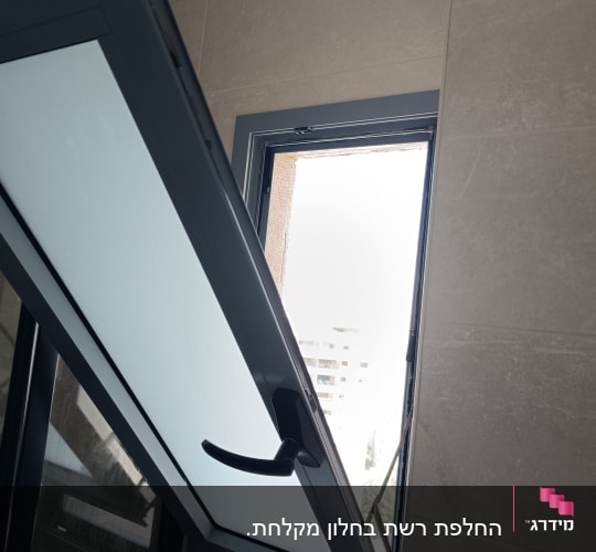 חלון פתוח עם מסגרת מתכת על קיר